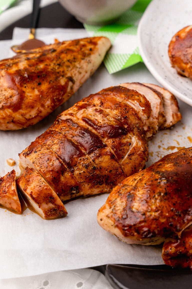 Tender, and juicy oven baked chicken with a rich BBQ sauce with all the flavors you love from summer grilling is easy to make and the perfect weeknight meal.