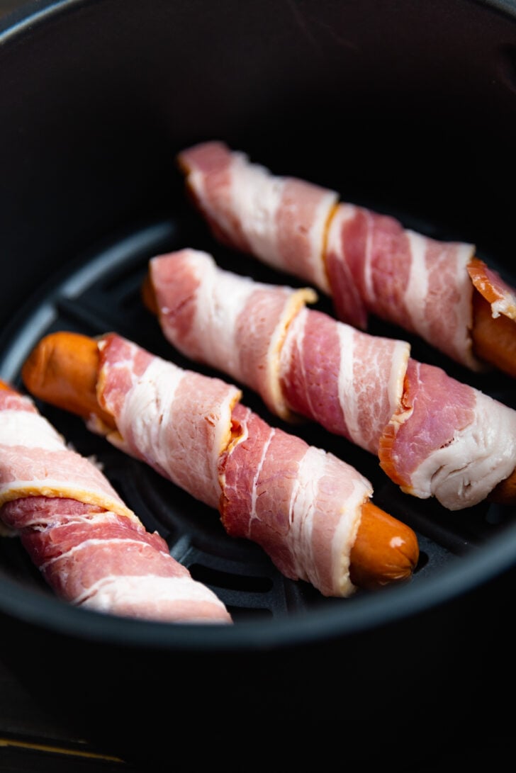 Bacon wrapped hot dogs made in the air fryer with toasted buns are great for lunch, dinner and always a favorite on game day.