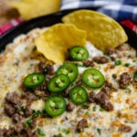 Tortilla chip dipped into Sausage Jalapeno Popper Dip baked in a cast iron skillet is creamy, meaty and spicy. It's a great hot appetizer to serve at family gatherings, parties, game day or anytime you are feeding a crowd.