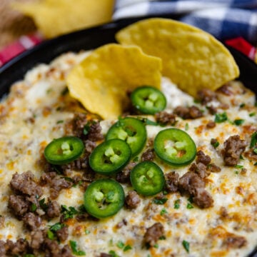 Tortilla chip dipped into Sausage Jalapeno Popper Dip baked in a cast iron skillet is creamy, meaty and spicy. It's a great hot appetizer to serve at family gatherings, parties, game day or anytime you are feeding a crowd.
