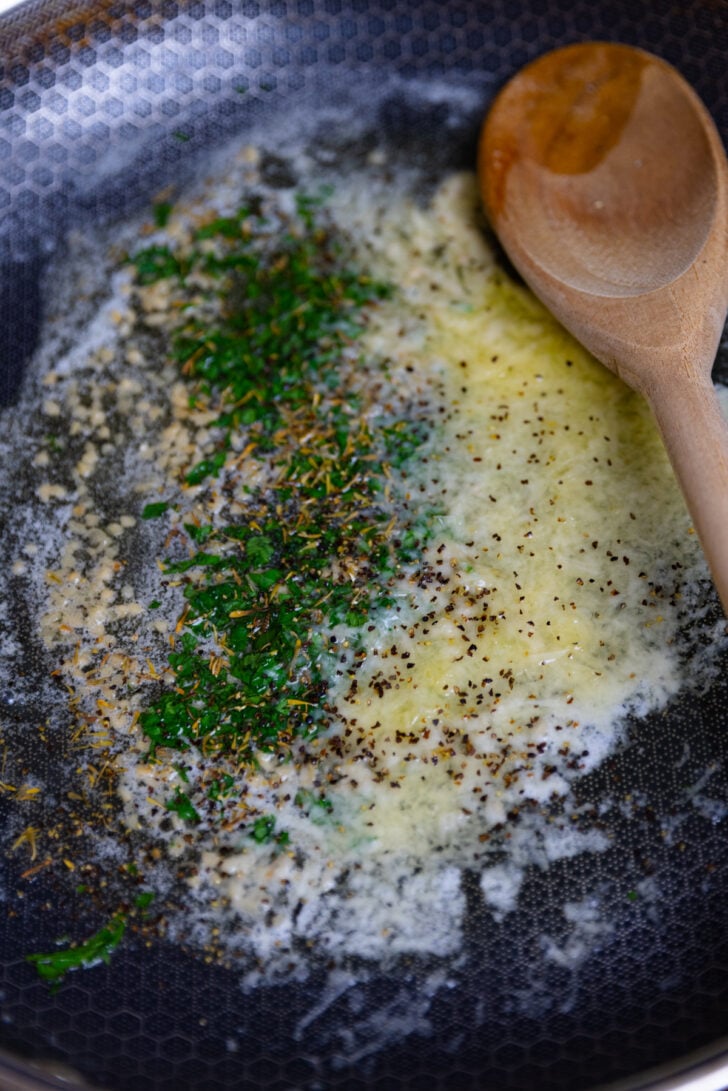 Melted butter, garlic, fresh parsley, dried thyme and grated parmesan cheese in a skillet make a sauce for Creamy Cheese Tortellini.