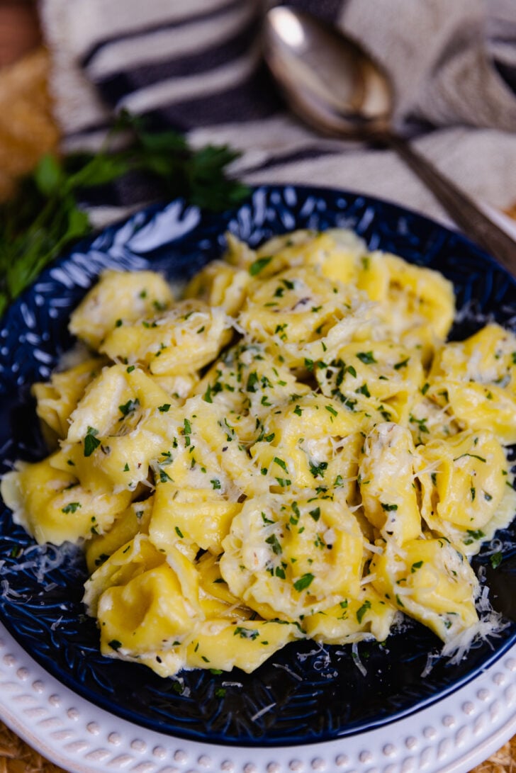 Creamy Cheesy Tortellini made on the stovetop is full of garlic, and herbs with a macaroni and cheese vibe making it a wonderful side dish! Served with extra