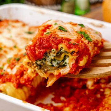 Lasagna roll up stuffed with spinach and cheese baked in tomato sauce then topped with shredded cheese and fresh basil.