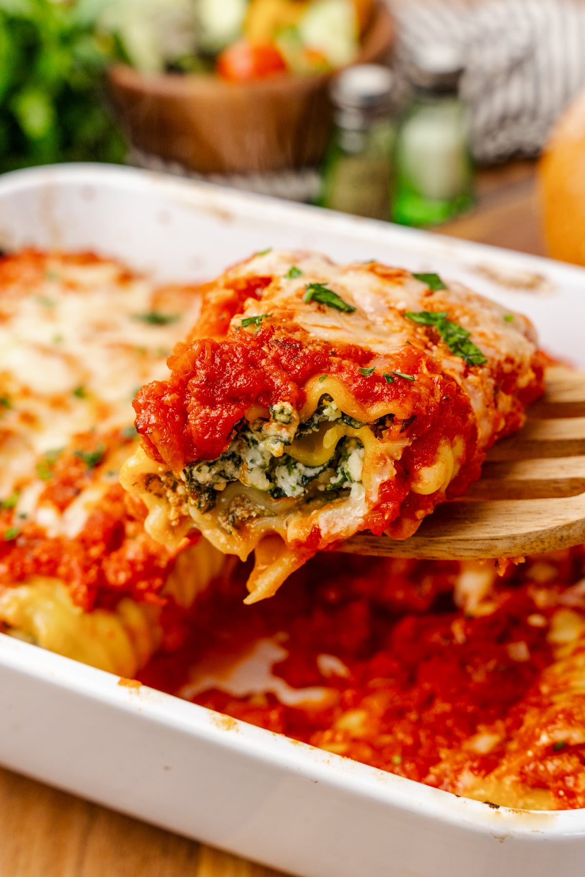 Lasagna roll up stuffed with spinach and cheese baked in tomato sauce then topped with shredded cheese and fresh basil.