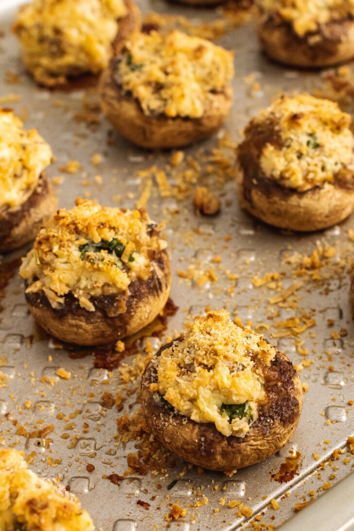 Baked mushrooms on a sheet pan stuffed with breadcrumbs, cream cheese, parmesan cheese, garlic and herbs are the perfect finger food for any party.