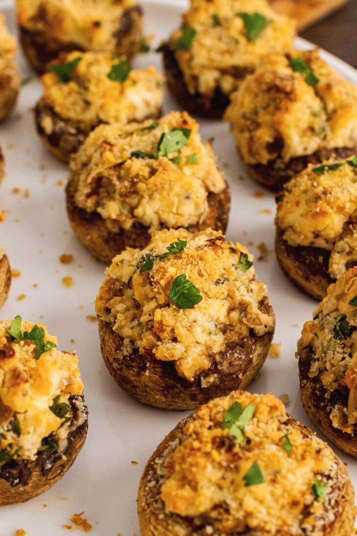 Baked mushrooms stuffed with breadcrumbs, cream cheese, parmesan cheese, garlic and herbs then sprinkled with shopped fresh parsley are the perfect finger food for any party.