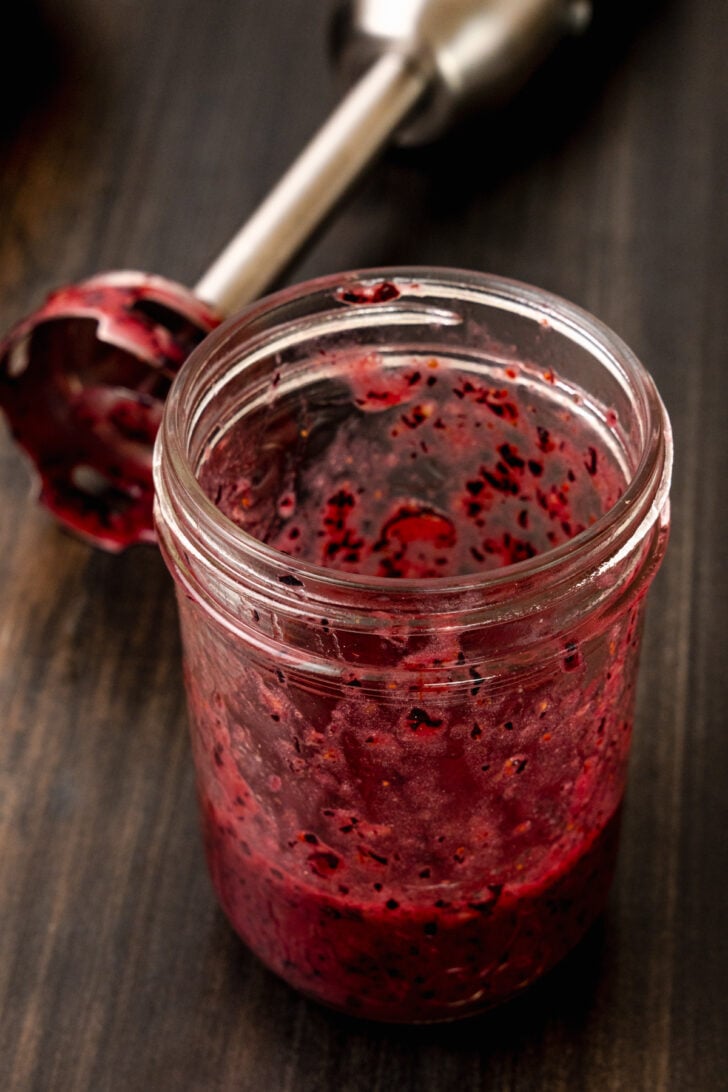 Jar of crushed blueberries for blueberry vinaigrette salad dressing.