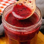 Spoonful of homemade blueberry vinaigrette salad dressing with lemon, olive oil and fresh crushed blueberries.