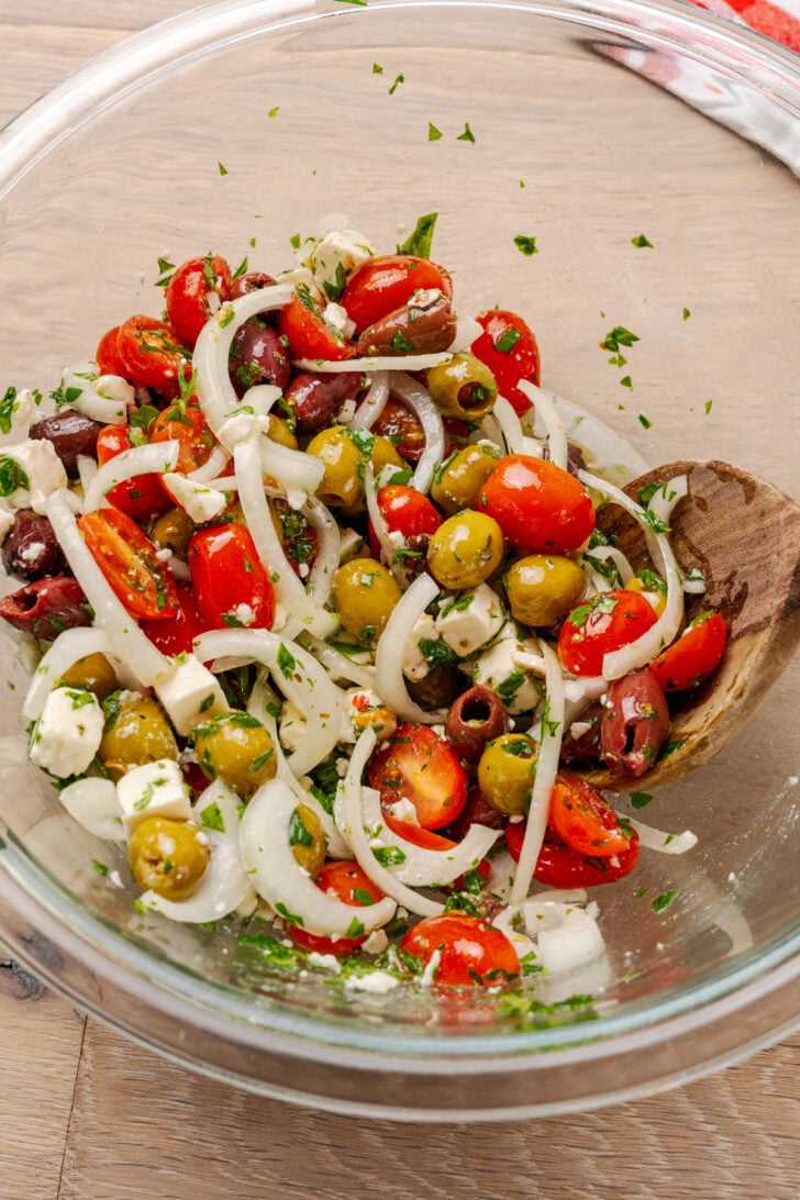 Grape tomatoes, sliced onions, green and black olives, feta cheese and herbs tossed in an olive oil dressing prepped for Greek pasta salad!