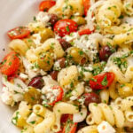 Greek pasta salad made with a store-bought shortcut is easy to make with pasta, feta cheese, tomatoes and onions in a light olive oil dressing. It's the perfect side dish or main to serve any time of the year!