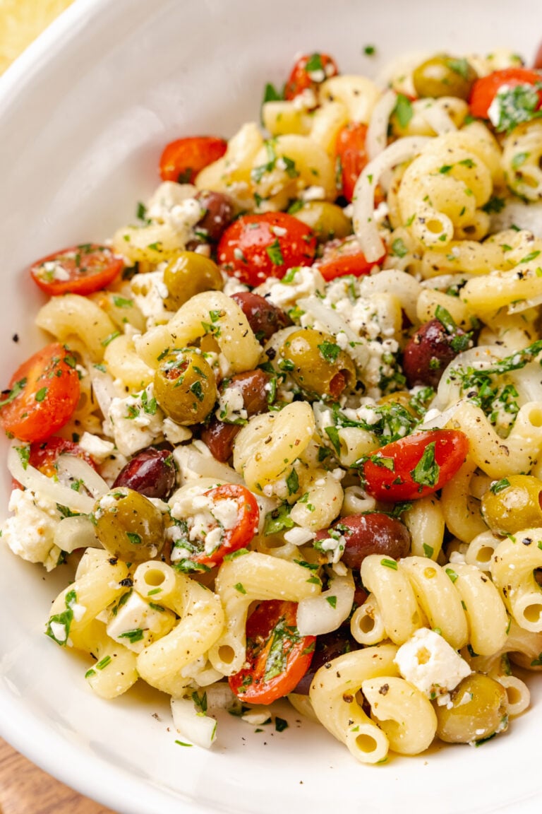 Greek pasta salad made with a store-bought shortcut is easy to make with pasta, feta cheese, tomatoes and onions in a light olive oil dressing. It's the perfect side dish or main to serve any time of the year!