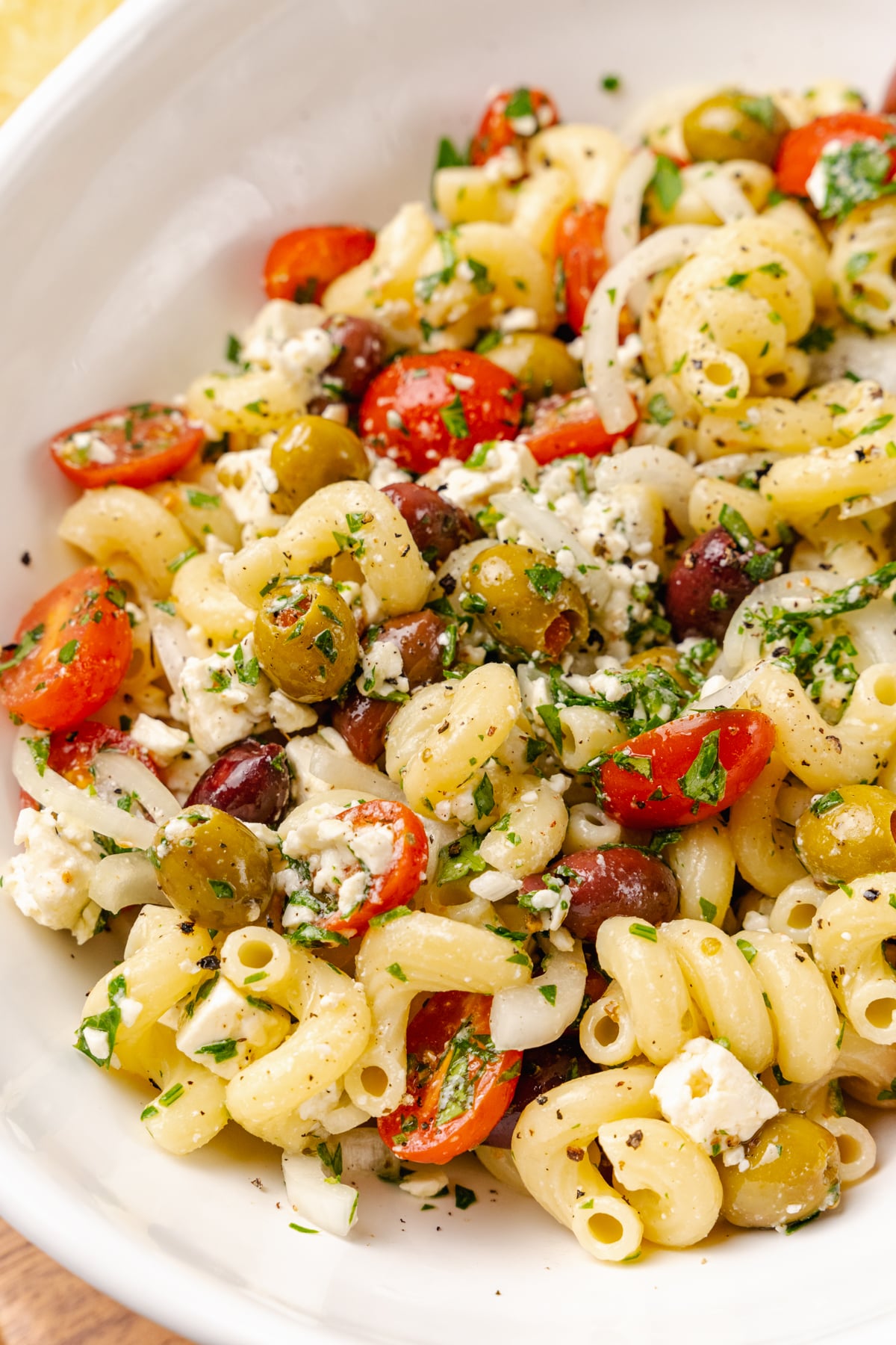 Greek pasta salad made with a store-bought shortcut is easy to make with pasta, feta cheese, tomatoes and onions in a light olive oil dressing. It's the perfect side dish or main to serve any time of the year!