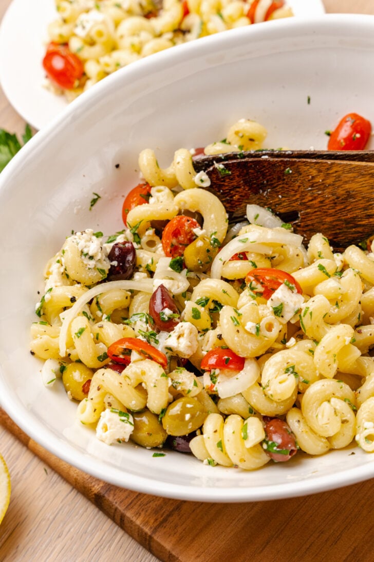 Greek pasta salad made with a store-bought shortcut is easy to make with pasta, feta cheese, tomatoes and onions in a light olive oil dressing. It's the perfect side dish or main to serve any time of the year!