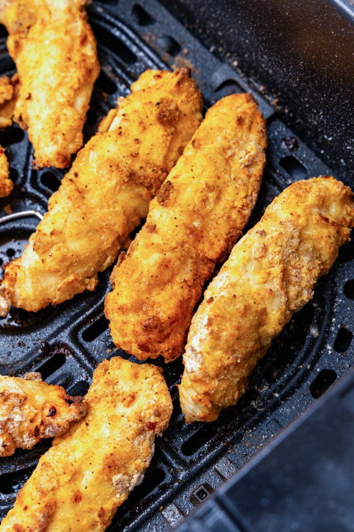 Chicken tenders cooked to golden brown and crispy in the air fyer for Nashville hot honey chicken.