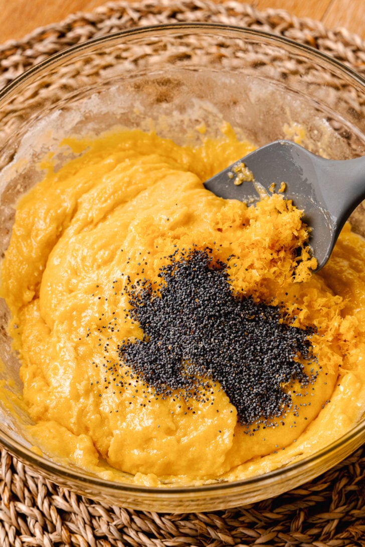 Lemon poppy seed batter with poppy seed ready to be baked in a muffin tin.