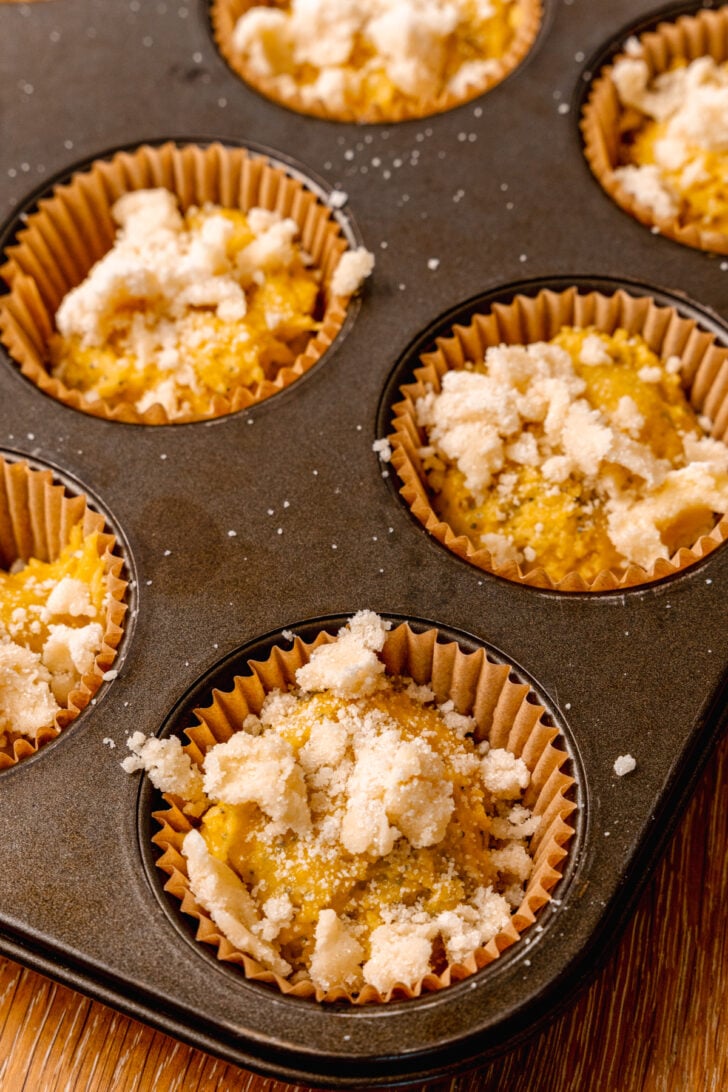Lemon poppy seed muffins in paper cups in a muffin pan ready to be baked for breakfast.