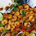 Flour tortillas, lime wedges, guacamole served with Sheet Pan Chili Lime Shrimp Fajitas.