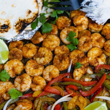 Flour tortillas, lime wedges, guacamole served with Sheet Pan Chili Lime Shrimp Fajitas.