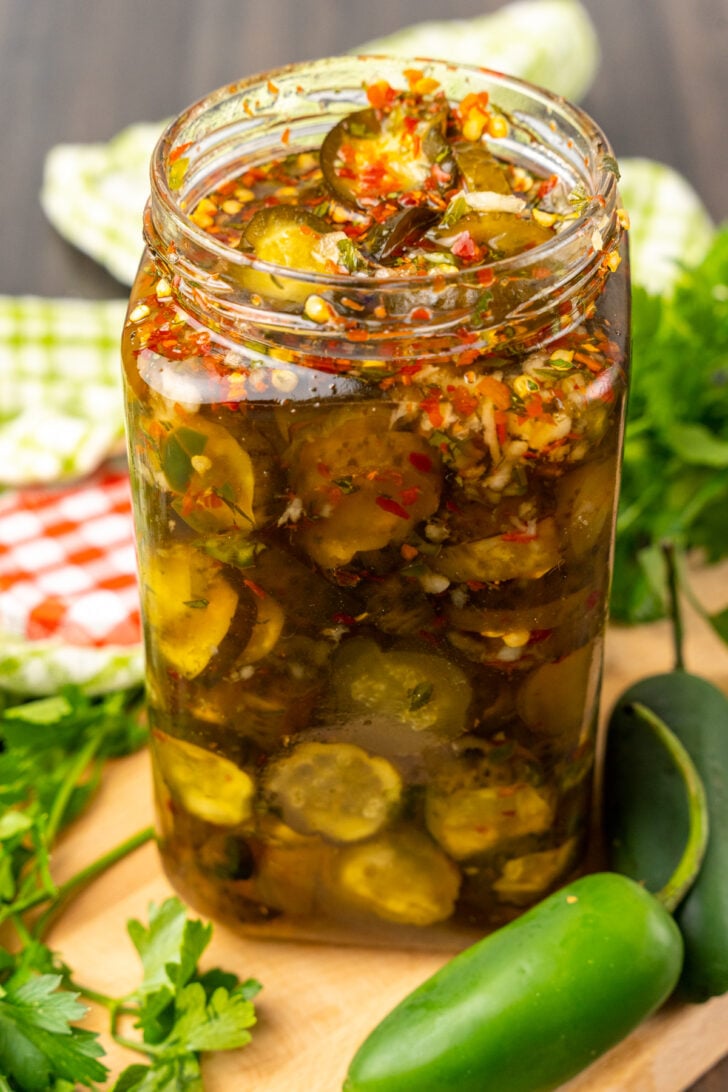 Sweet Heat Pickles marinated in red pepper, sugar, garlic, parsley and jalapeños are crazy delicious and so easy to make. They are great as a snack, with burgers, chicken, and perfect for a charcuterie board!