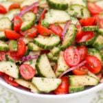 Tomato Cucumber Salad with homemade dressing in a white bowl.