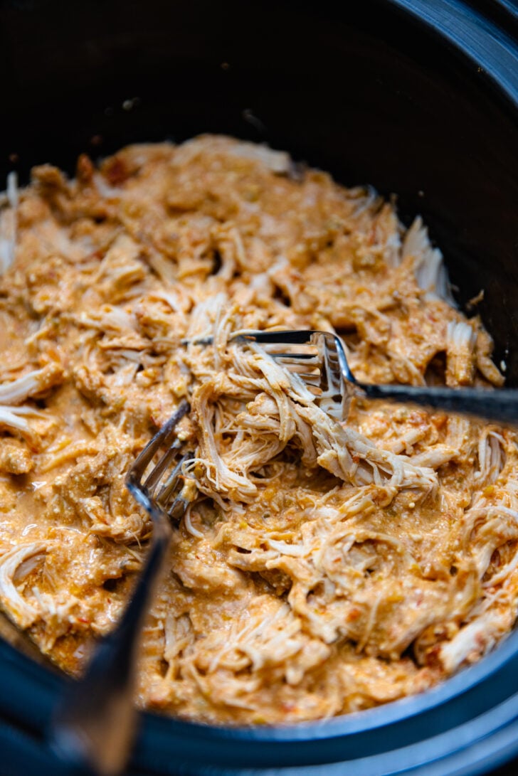 Shredded chicken cooked in the crock pot in salsa and cream cheese then pulled apart with 2 forks.