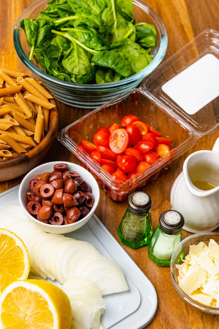 Spinach, tomatoes, whole wheat penne pasta, black olives, onions, salt and pepper for pasta salad tossed in lemon juice, olive oil, salt and pepper.