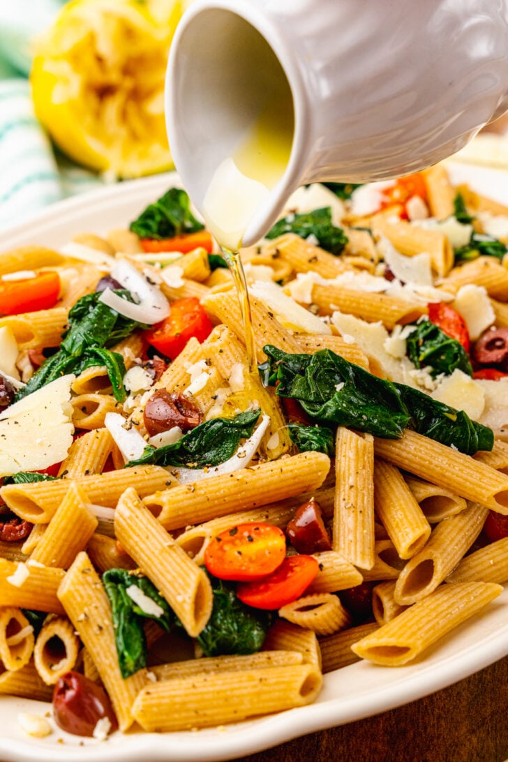 Whole wheat penne pasta tossed with fresh tomatoes, spinach, black olives in lemon juice and olive oil the topped with shaved Parmesan Cheese.