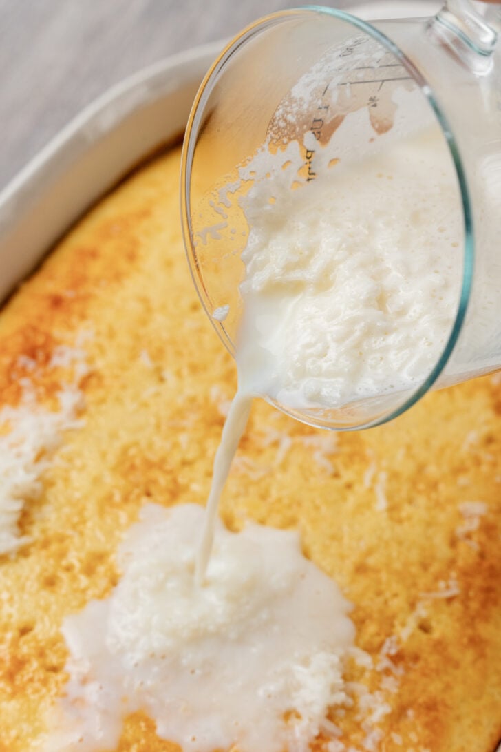 Coconut and milk mixed together poured over a baked white box cake in a square pan.