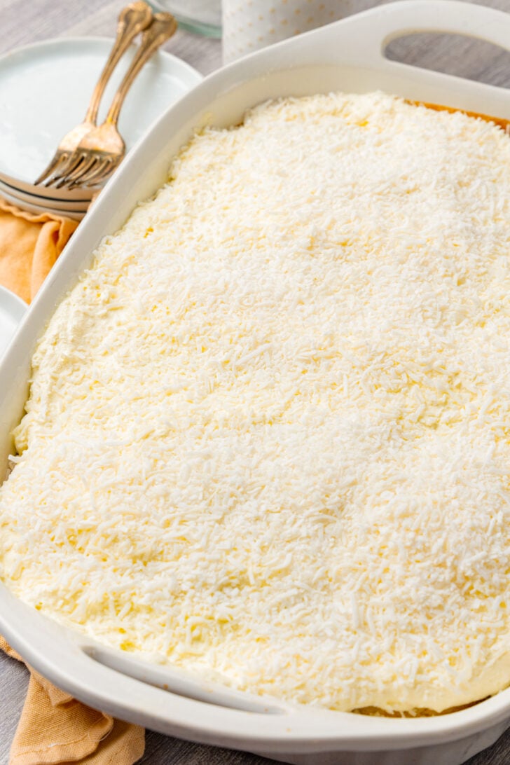 Sheet pan coconut cake made with a cake mix and topped with whipped topping and coconut.