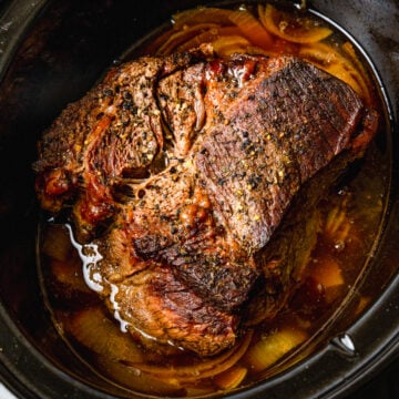 Beef pot roast cooked in the crock pot with onions and seasoned perfection until tender and juicy.