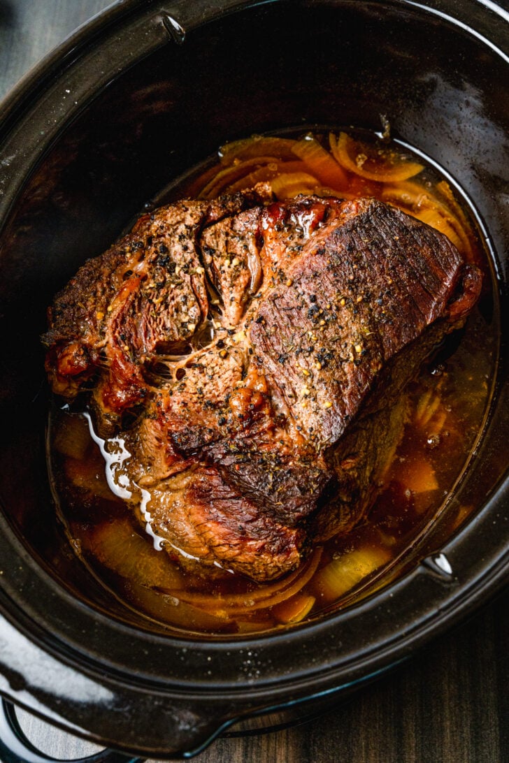 Beef pot roast cooked in the crock pot with onions and seasoned perfection until tender and juicy.