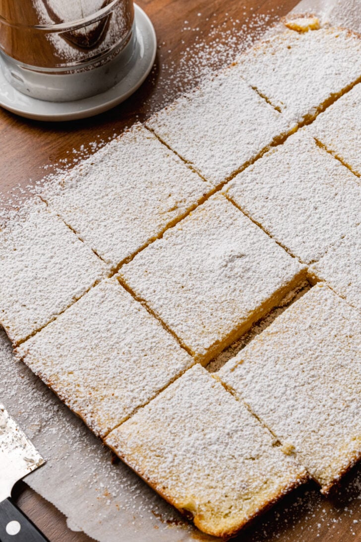 Baked lemon bars sprinkled with powdered sugar and cut into squares.
