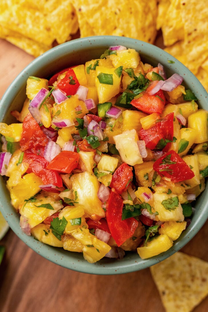 Close up of fresh pineapple salsa served with corn tortilla chips.