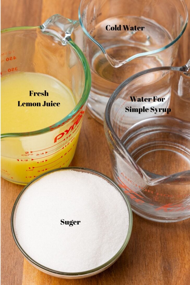 Lemon juice, water and sugar in glass containers for homemade lemonade.