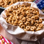 Brown paper bag with fried buttered cheerios tossed in cinnamon sugar.