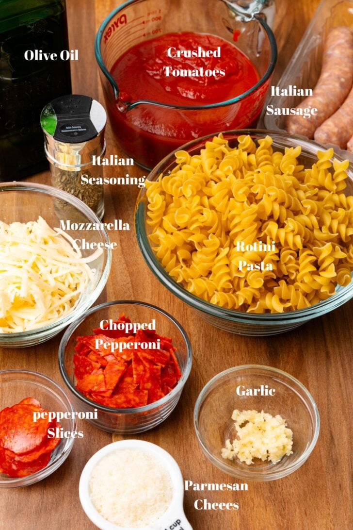 Crushed tomatoes, pasta, Italian seasoning, mozzarella cheese, pepperoni, garlic, and Parmesan cheese for pizza pasta bake.