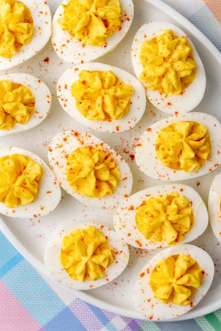 Stuffed deviled eggs on a white plate, sprinkled with paprika.