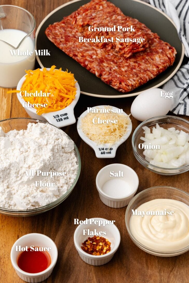 Ingredients to make sausage cheese bread laid out neatly on a table in bowls.