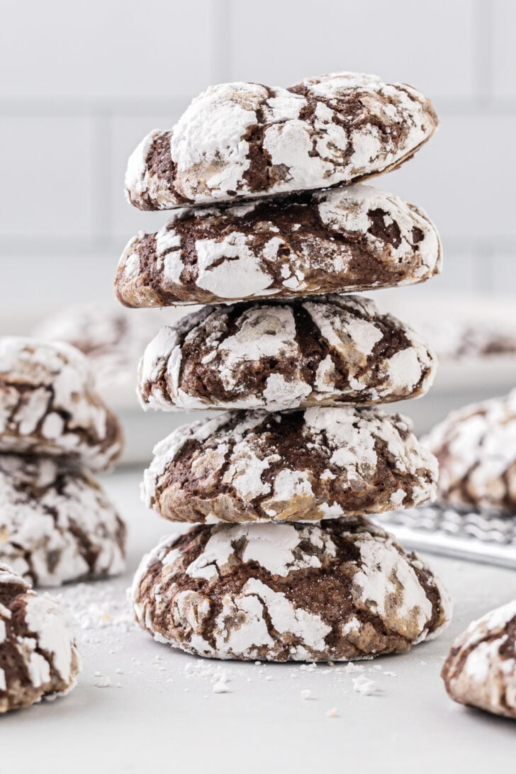 Crinkle cookies stacked neatly on top of each other on top of a table.