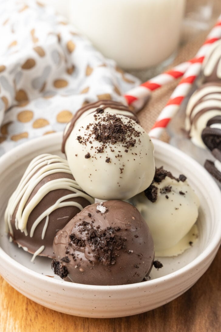 Beautiful chocolate Oreo truffles with a sprinkle of chocolate dusting on top inside a bowl.