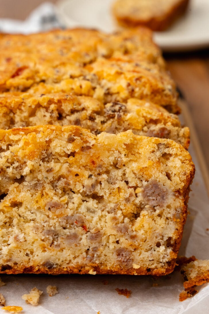 Sausage cheese bread cut into slices on top of a cutting board.