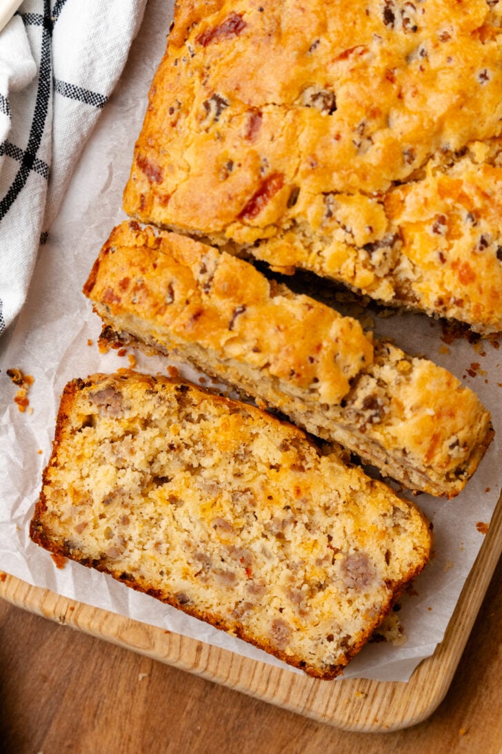 Sausage cheese bread cut into slices on top of a cutting board.