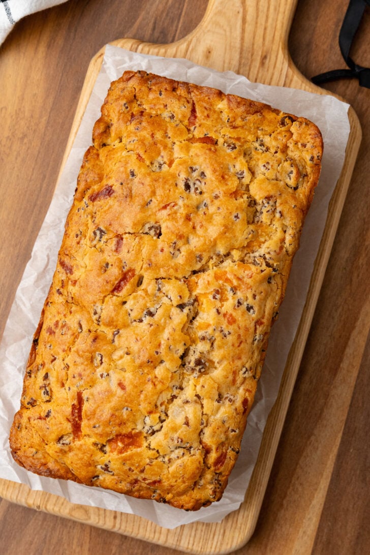 Sausage cheese bread perfectly baked sitting on a cutting board.