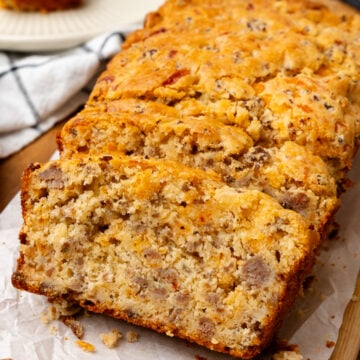 Sausage cheese bread cut into slices on top of a cutting board.