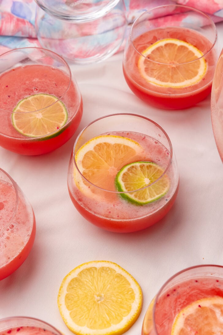 Clear small glasses filled with fruit punch topped with lemaon and lime slices.
