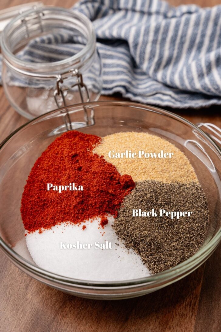Ingredients to make a house seasoning blend. Paprika, kosher salt, black pepper and garlic powder. Sitting in small bowls.