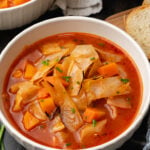 White bowl filled to the top with cozy cabbage soup.