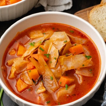 White bowl filled to the top with cozy cabbage soup.