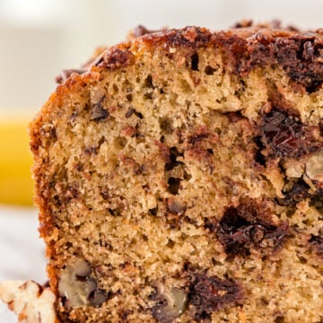 The corner of chocolate chip banana bread. the cross section has melty bits of chocolate and fluffy bread.
