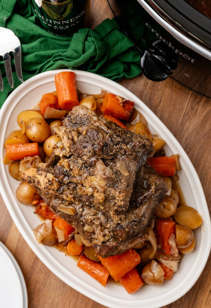 Overhead shot of the Irish pot roast in a white serving dish with serving fork.